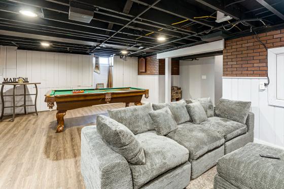 Basement rec room combining the pool table with an oversized sectional sofa
